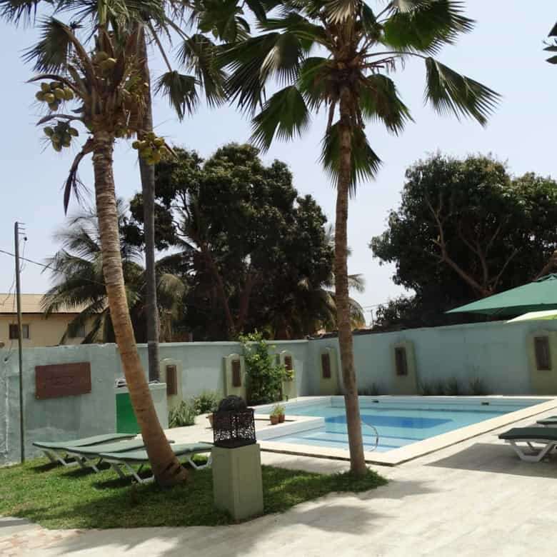Beautiful tropical garden with pool and palm trees at a bed and breakfast in Kombo North district.