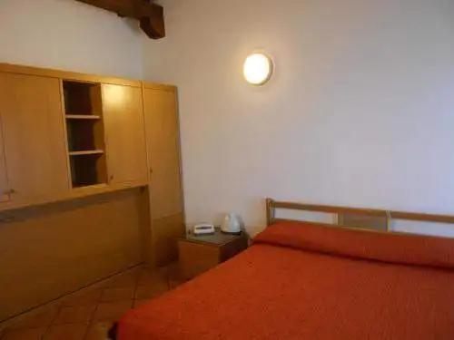 Hotel room interior with wooden furniture and warm lighting near Lake Viverone, Piverone, Italy.