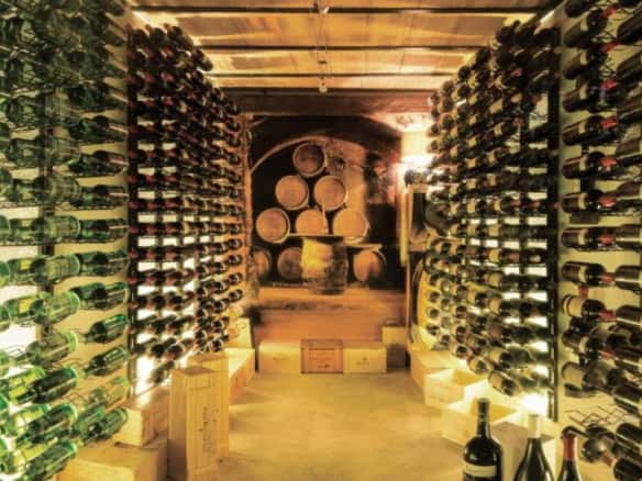 Luxurious wine cellar with wooden racks filled with wine bottles in Marbella apartment.