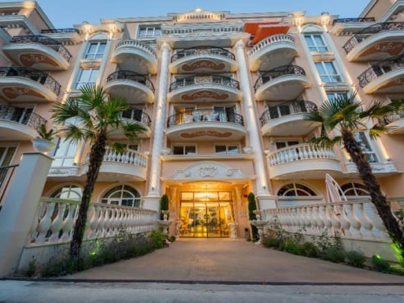 Elegant Venera Palace building with balconies and lush landscaping in Sunny Beach.