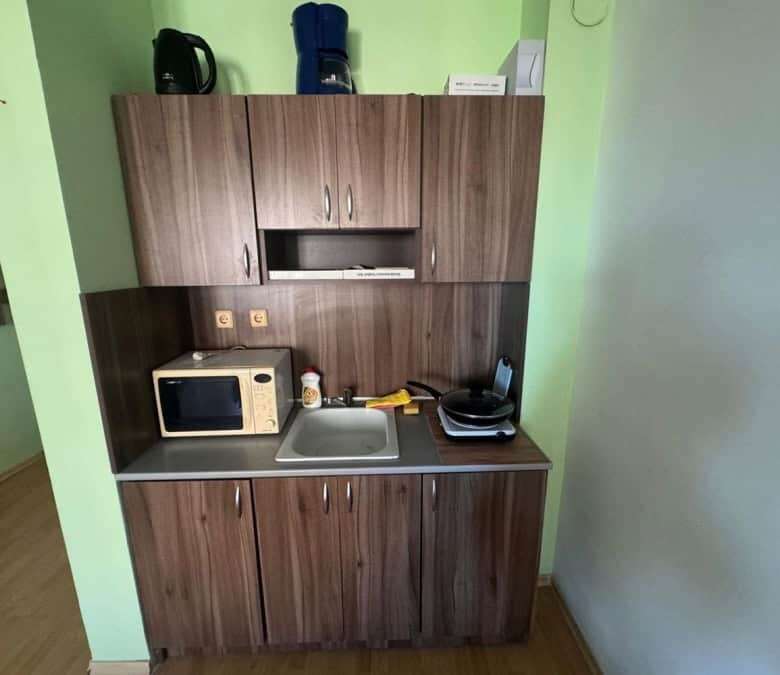 Compact kitchen with microwave, sink, and storage in St. Vlas studio.