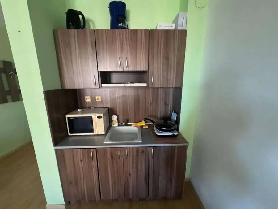 Compact kitchen with microwave, sink, and storage in St. Vlas studio.