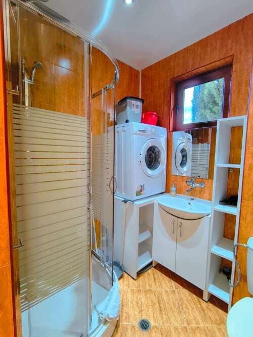 Bright bathroom with washing machine and storage in Sveti Vlas, close to the sea.