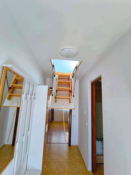 Bright interior of a 1-bedroom apartment with access to a staircase leading to the sea view.