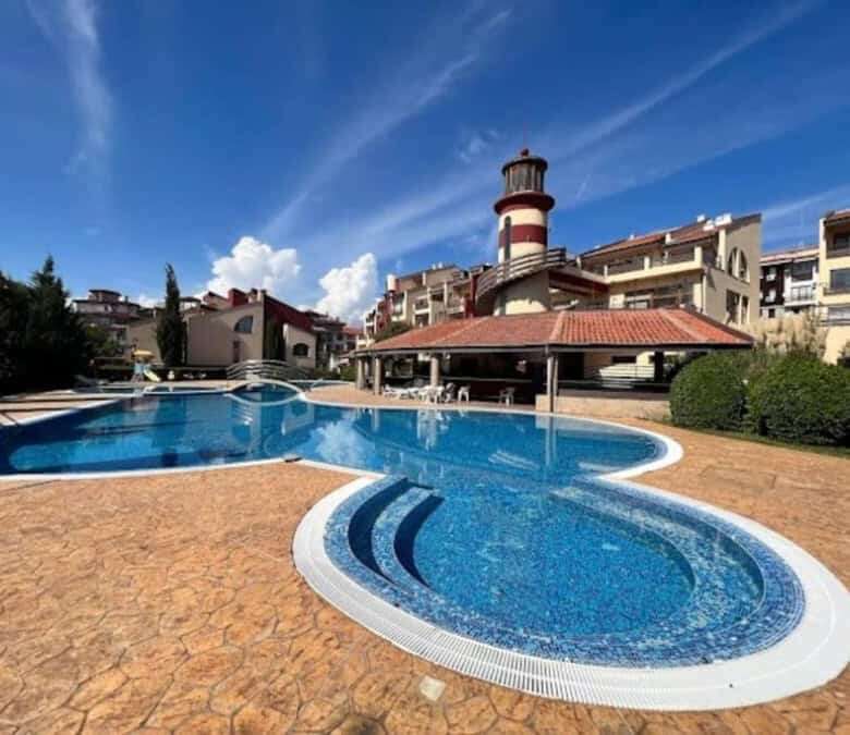 Swimming pool at Sea Lighthouse in Sveti Vlas, close to the sea, featuring a unique lighthouse backd.