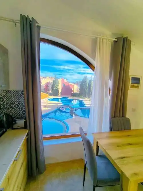 Bright studio apartment near the sea in Sveti Vlas, featuring a large window with scenic ocean views.