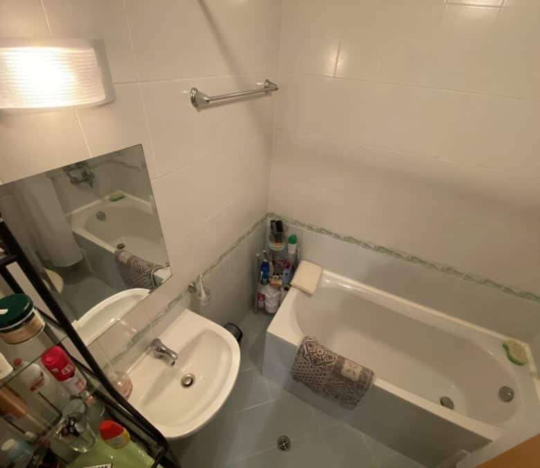 Bright bathroom with bathtub and essential amenities.