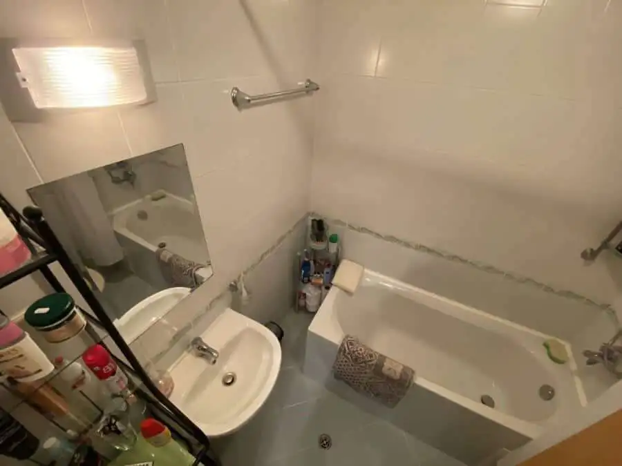 Bright bathroom with bathtub and essential amenities.