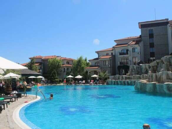Pool area at Vineyards SPA Resort near the sea, featuring relaxing loungers and umbrellas.