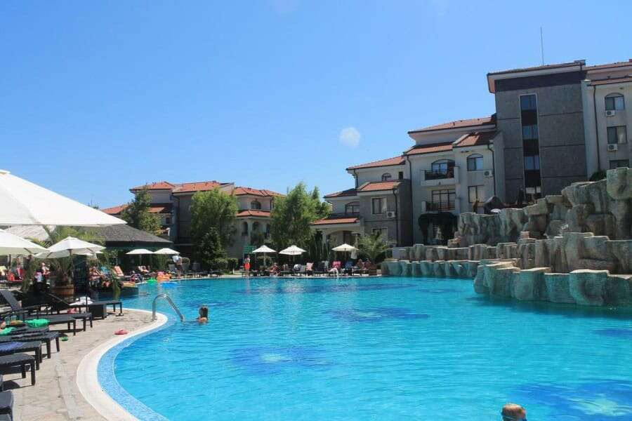 Pool area at Vineyards SPA Resort near the sea, featuring relaxing loungers and umbrellas.