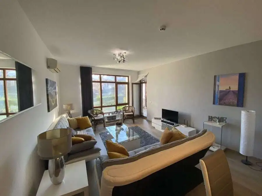 Bright living room with large windows and stylish furniture.
