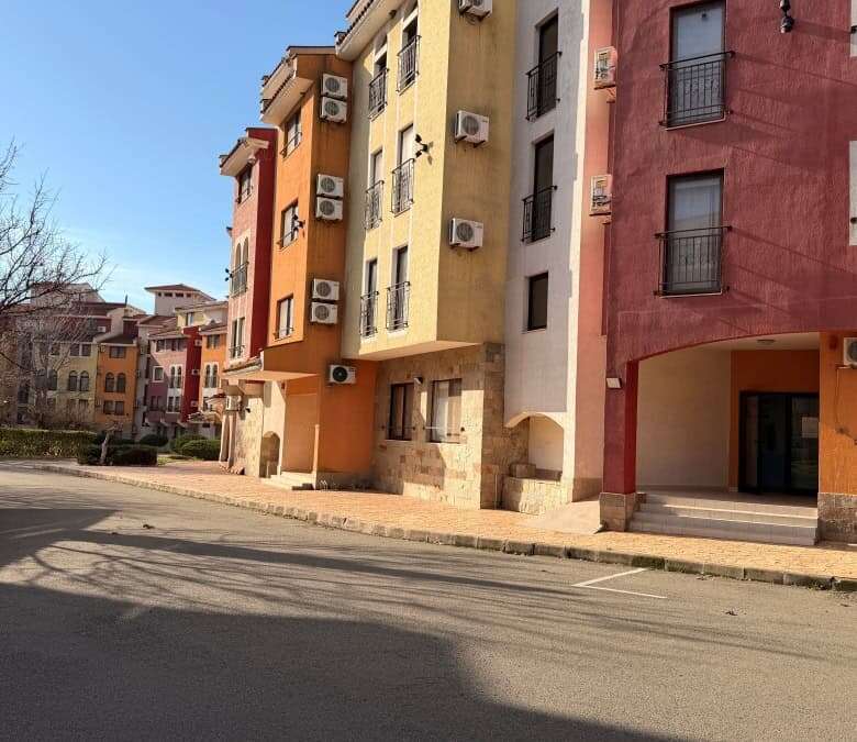 Apartment building with vibrant colors and air conditioning units in Aheloy, Bulgaria.