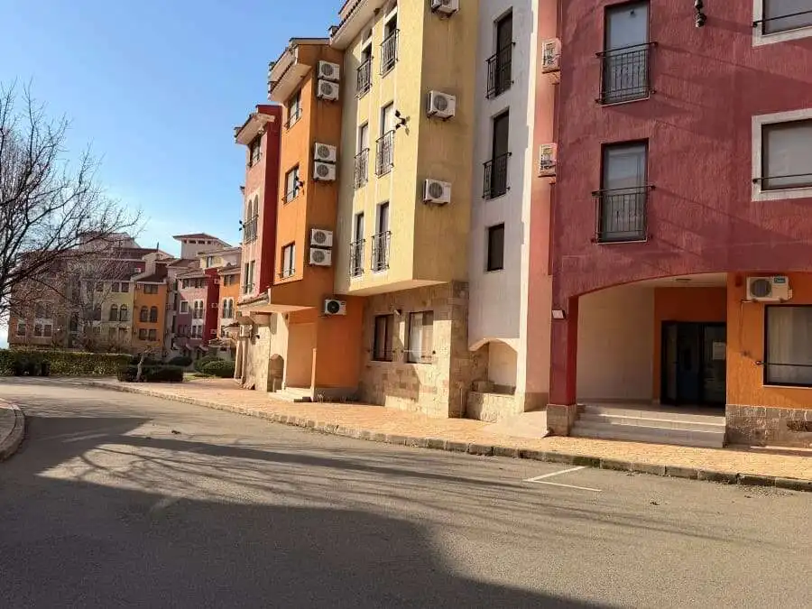 Apartment building with vibrant colors and air conditioning units in Aheloy, Bulgaria.