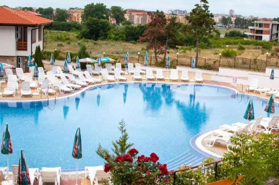 Bright outdoor pool area with sun loungers and umbrellas at Gardenia Hills.