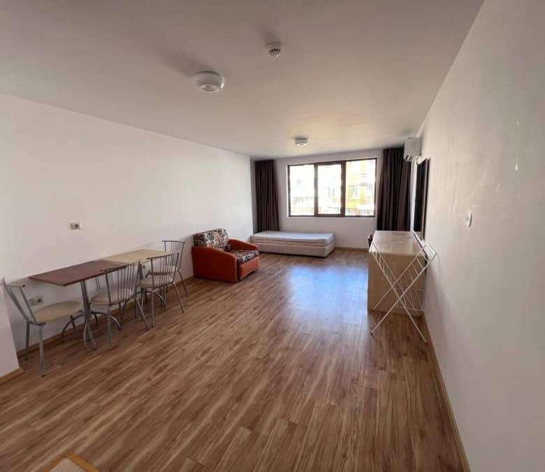 Apartment interior with living area, dining space, and large window views.