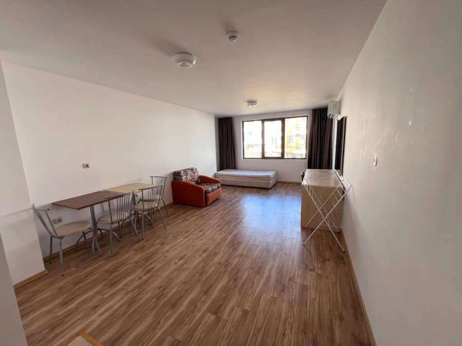 Apartment interior with living area, dining space, and large window views.