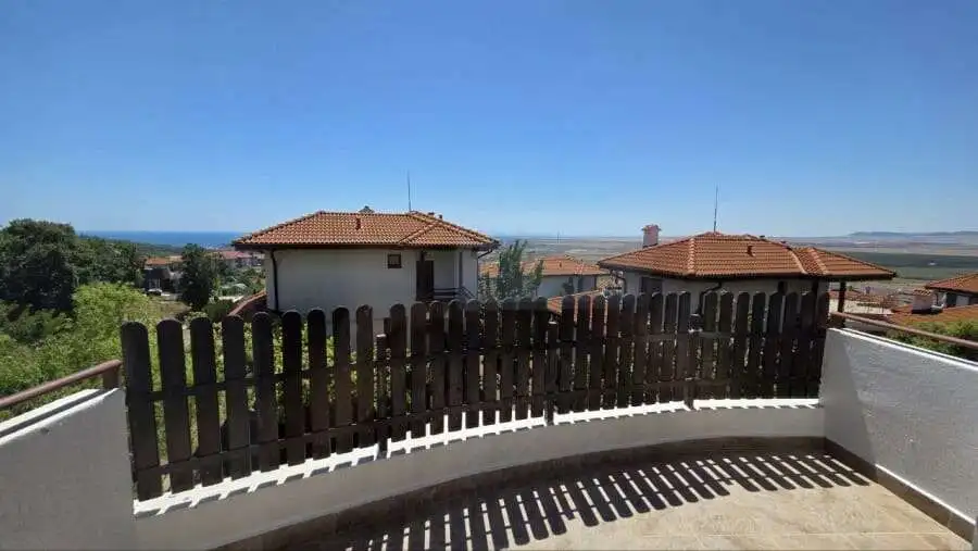 View of a modern villa with a wooden fence and sea in the background in Bulgaria.