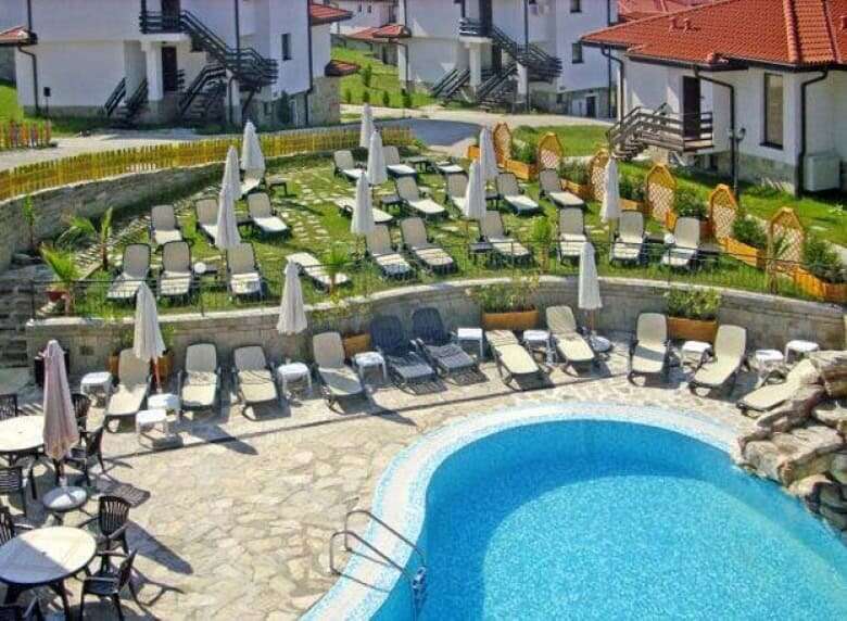 Beautiful outdoor pool area with lounge chairs and umbrellas in a residential community.