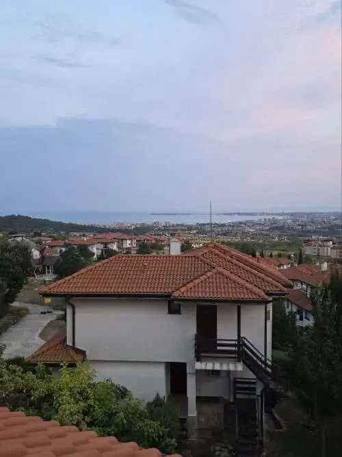 Two-story maisonette with red-tiled roof overlooking a scenic landscape in Bulgaria.