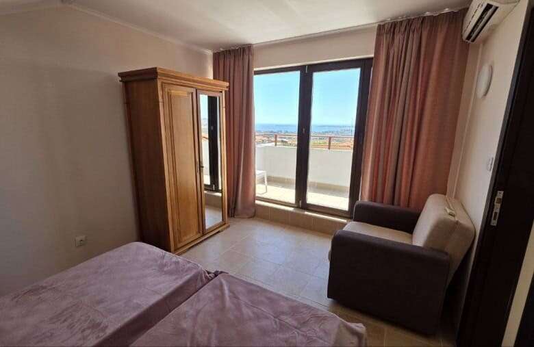 Bright bedroom with large window overlooking the sea in Bay View Villas, Kosharitsa, Bulgaria.