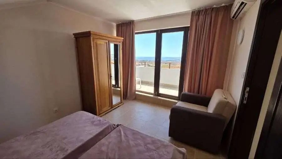 Bright bedroom with large window overlooking the sea in Bay View Villas, Kosharitsa, Bulgaria.