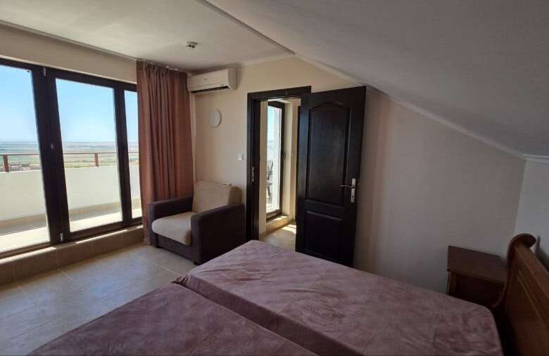 Bright living space with balcony access and scenic views near the sea in Kosharitsa, Bulgaria.
