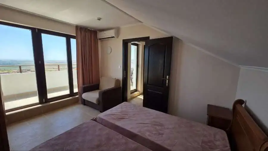 Bright living space with balcony access and scenic views near the sea in Kosharitsa, Bulgaria.