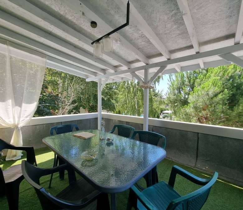 Spacious balcony with outdoor dining area and lush green views in Sunny Beach.