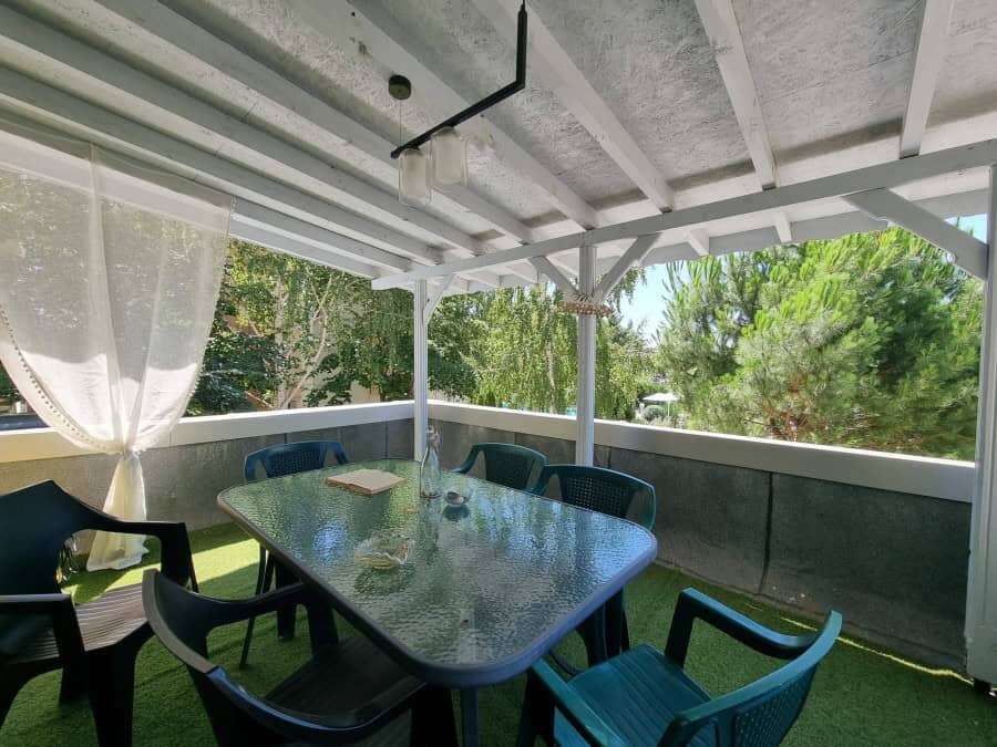 Spacious balcony with outdoor dining area and lush green views in Sunny Beach.