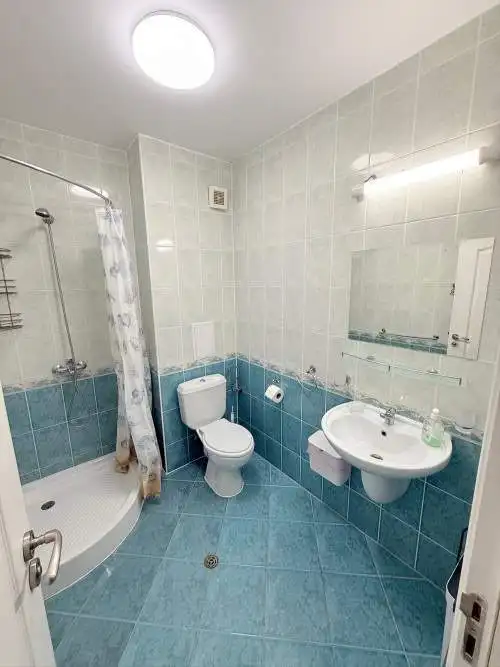 Ground floor bathroom with shower, toilet, and sink in a sunny beach resort.