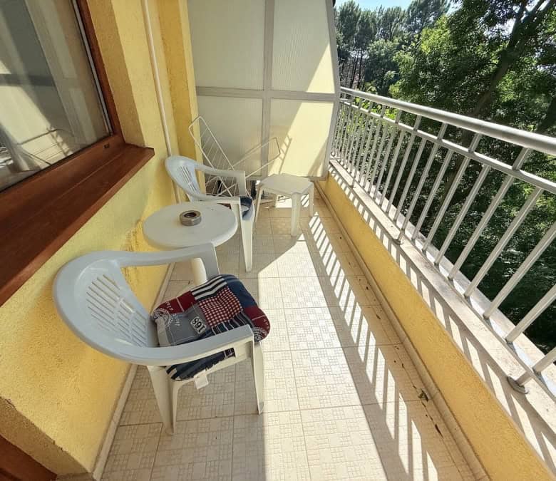 Balcony with two white chairs and small table overlooking lush greenery in Summer Dreams, Sunny Beac.