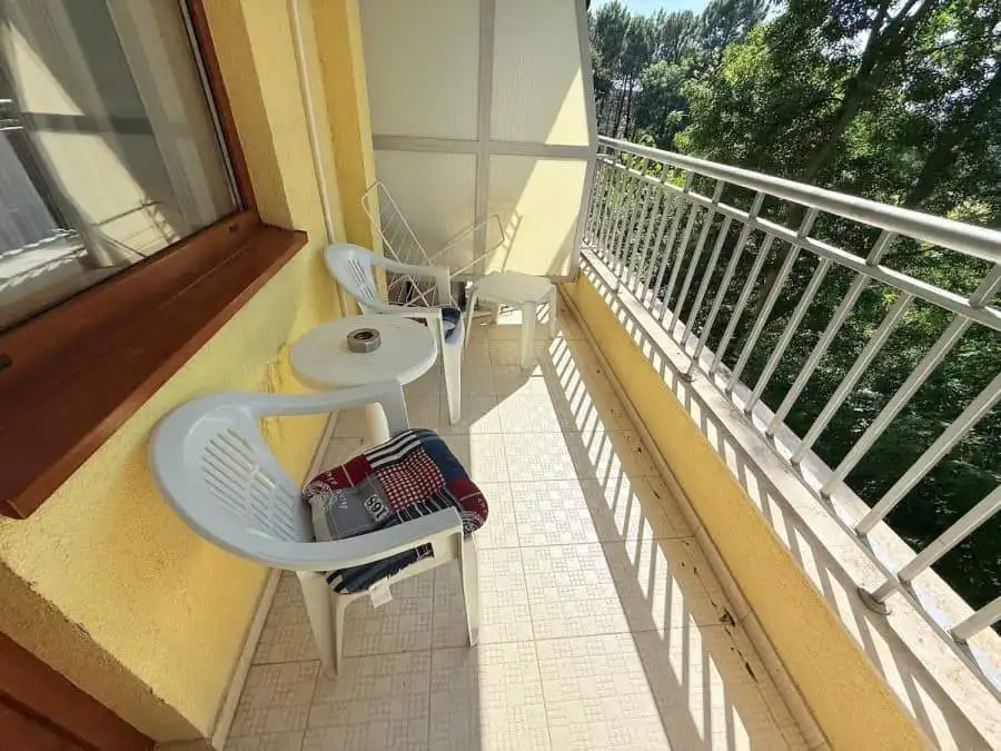 Balcony with two white chairs and small table overlooking lush greenery in Summer Dreams, Sunny Beac.