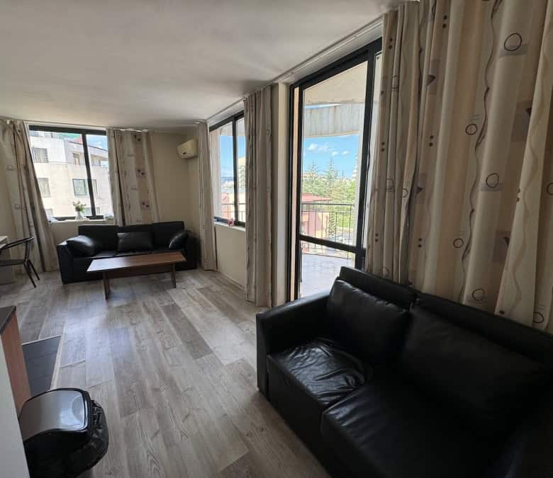Bright living room with large windows and terrace in Avalon Sunny Beach apartment.
