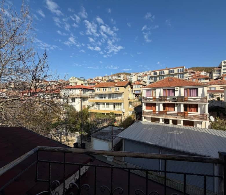 Bright sea view 1-bedroom apartment in Sveti Vlas center with cityscape and blue sky.