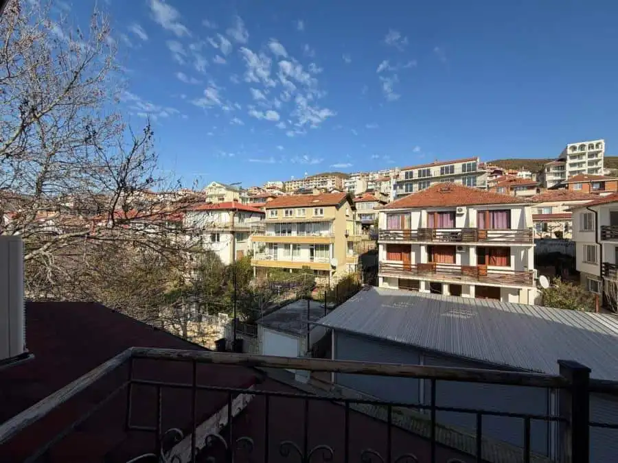 Bright sea view 1-bedroom apartment in Sveti Vlas center with cityscape and blue sky.