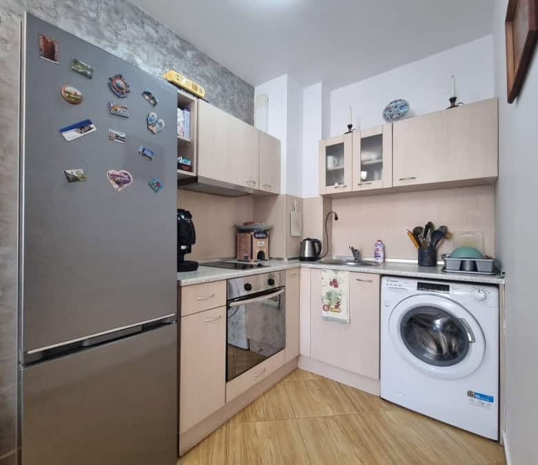 Modern kitchen with fridge, oven, washing machine, and appliances in Golden Dreams, Sunny Beach.