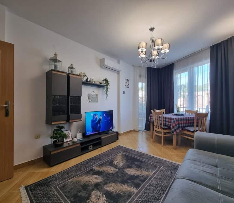 Bright living room with TV, dining table, and large windows in Golden Dreams, Sunny Beach.
