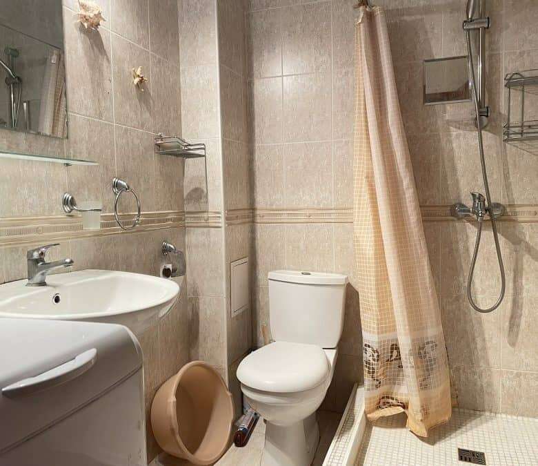 Modern bathroom with shower, toilet, and beige tiles in Sveti Vlas apartment.