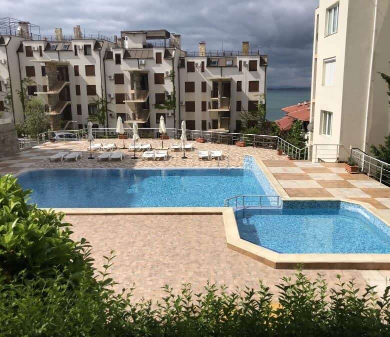 Pool area with sun loungers and umbrellas overlooking the Black Sea.