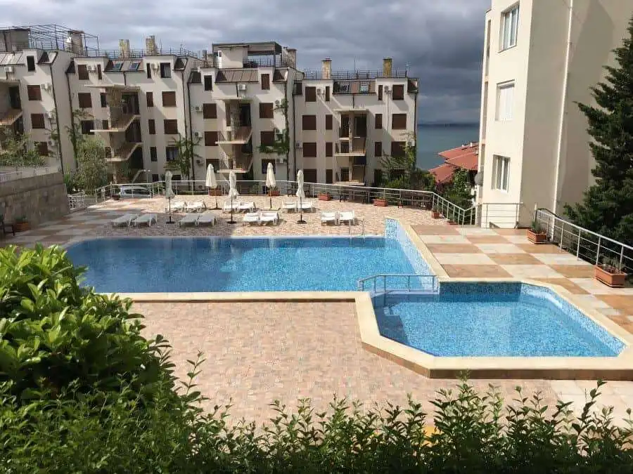 Pool area with sun loungers and umbrellas overlooking the Black Sea.