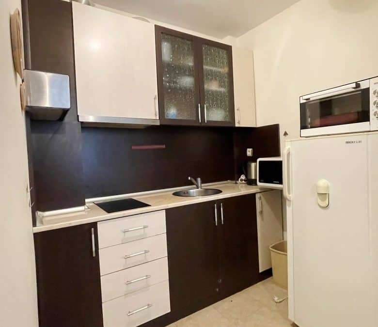 Modern fully equipped kitchen with white and dark cabinetry in Vista Residence, Sveti Vlas, Bulgaria.