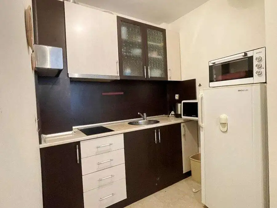 Modern fully equipped kitchen with white and dark cabinetry in Vista Residence, Sveti Vlas, Bulgaria.