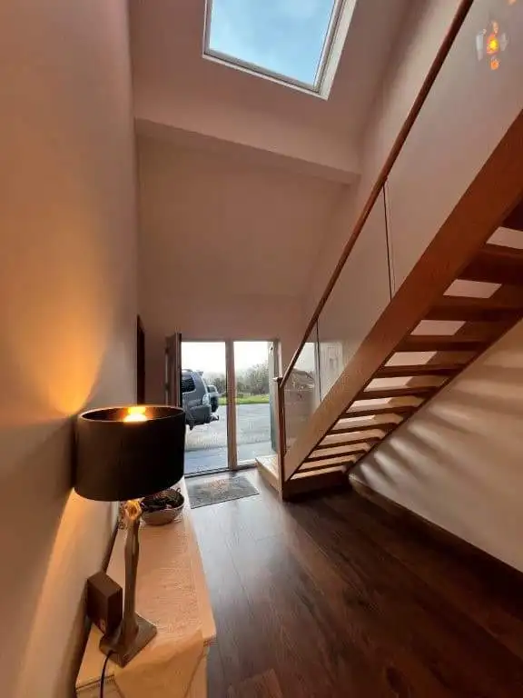 Stylish staircase and skylight bring natural light into the modern interior space.