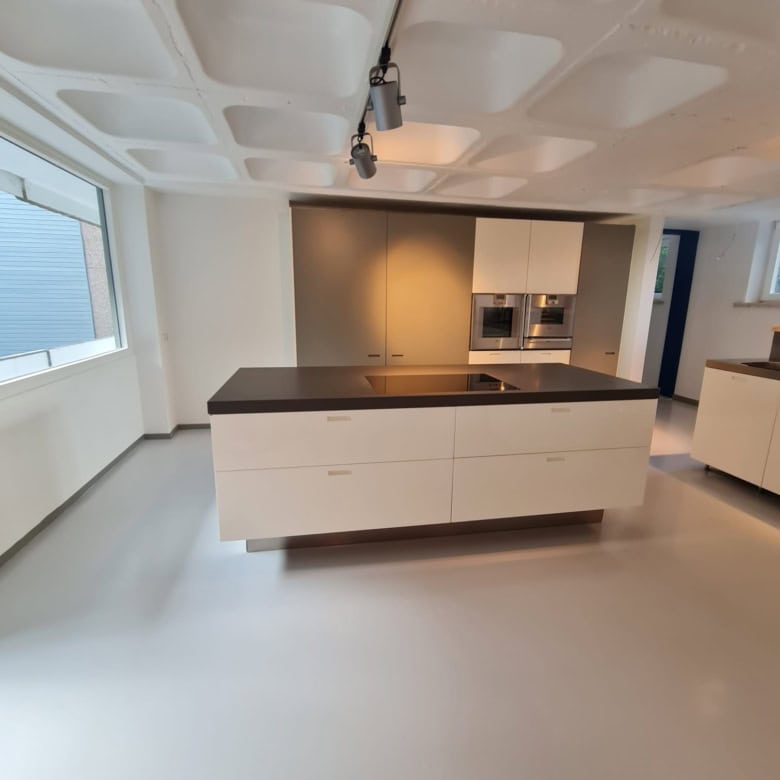 Modern kitchen with sleek white cabinets and black countertops in a luxury villa in Bad Harzburg, Ni.