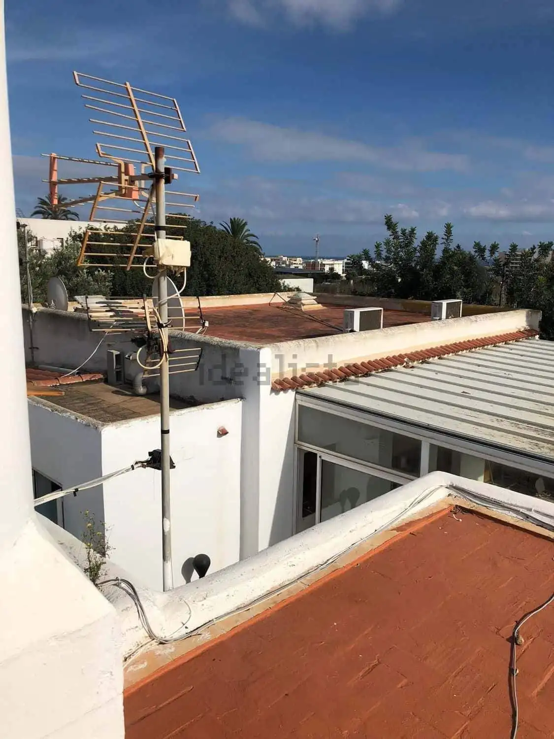 Aerial view of rooftops in Playa Den Bossa, Ibiza, showcasing the villa estate with two houses for s.