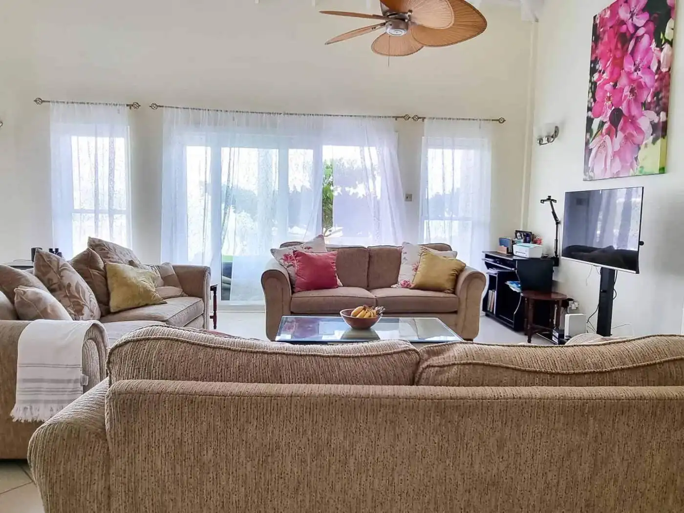 Elegant living room with large windows and comfortable sofas in Saint George, Grenada.