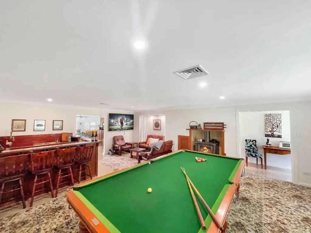 Vineyard Estate with 2 Homes for Sale in Broke Spacious living room with a pool table, cozy fireplace, and elegant decor at the Vineyard Estate in.