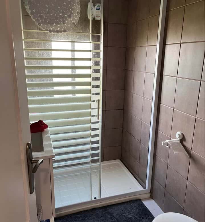 Shower room with glass enclosure in a mobile home at Camping Castillejo Fortuna, Spain.