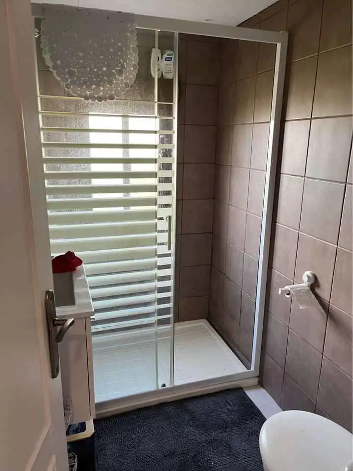 Shower room with glass enclosure in a mobile home at Camping Castillejo Fortuna, Spain.