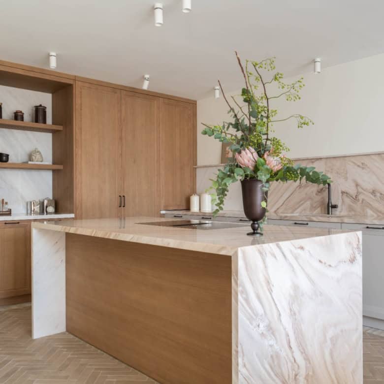 Bright, contemporary kitchen featuring wooden cabinetry and a marble-topped island, perfect for styl.
